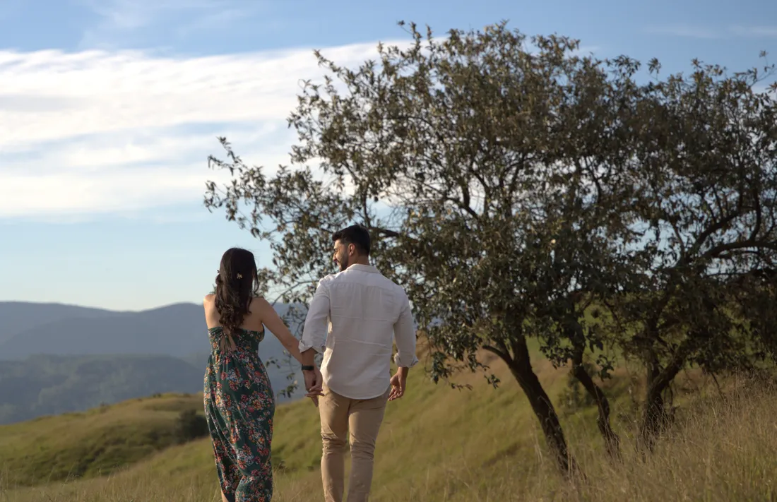 Casal caminhando entre o capim dourado